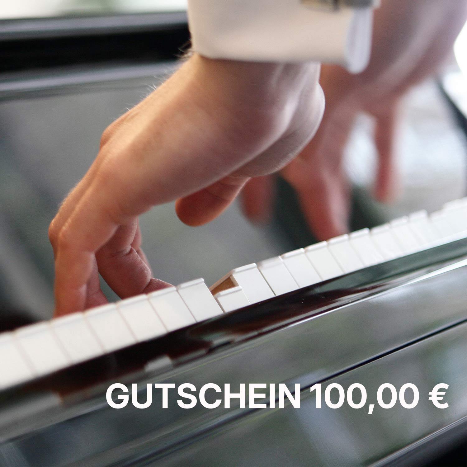 Nahaufnahme einer Hand, die Klaviertasten spielt, mit Text "Gutschein 100,00 €" im Vordergrund.